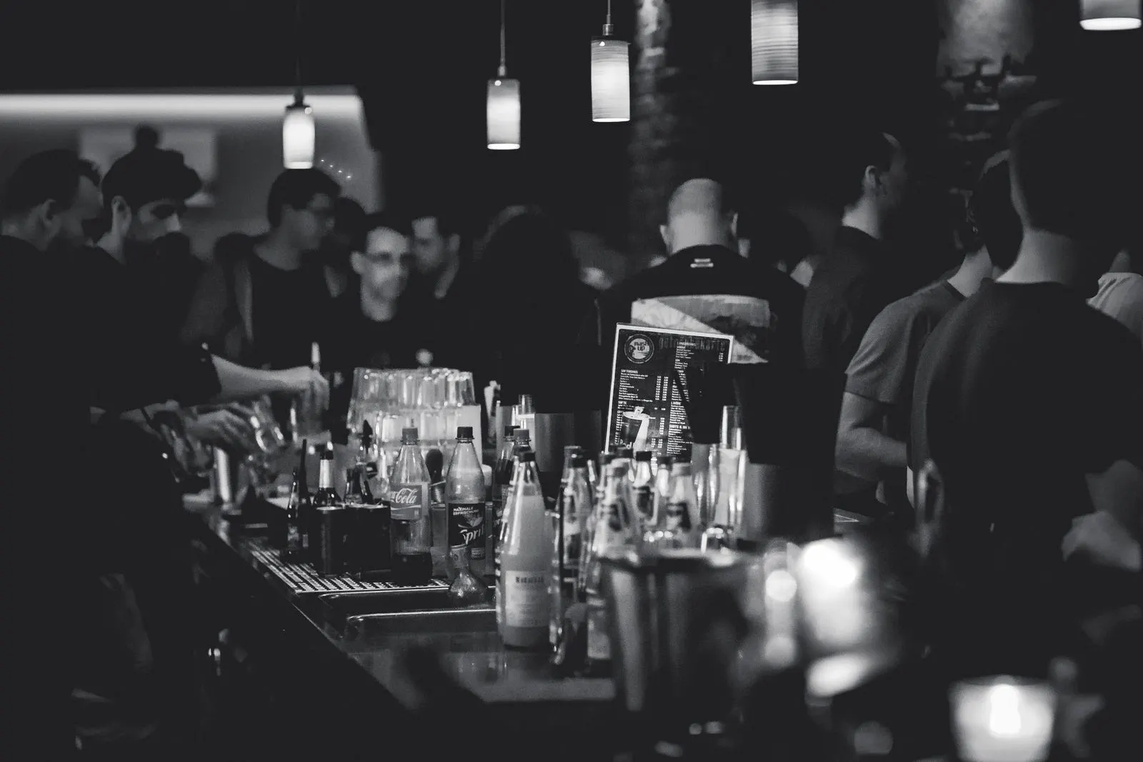 Salle de bar, le soir, en noir et blanc.